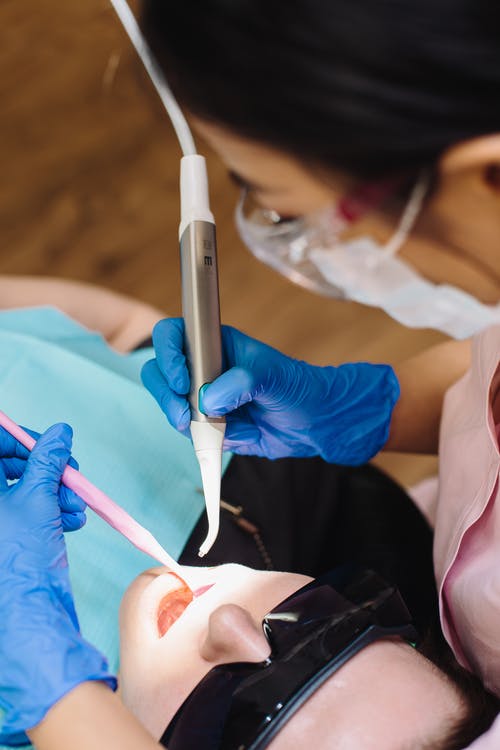 A woman having a dental procedure from a dentist
